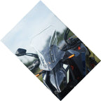 Adventure motorcycle with clear windscreen and LED front lights outdoors