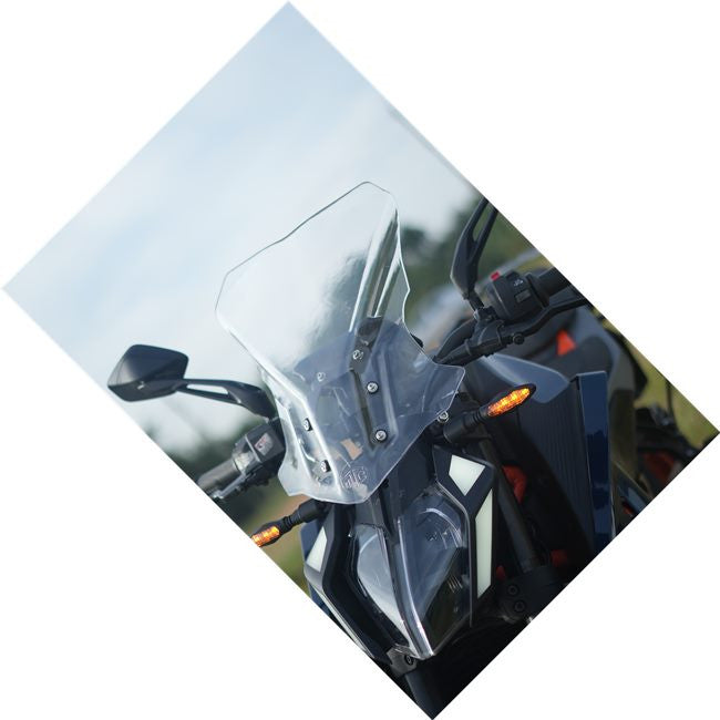 Adventure motorcycle with clear windscreen and LED front lights outdoors