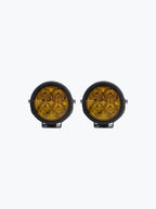 Pair of round yellow motorcycle LED fog lights with black housing on a white background