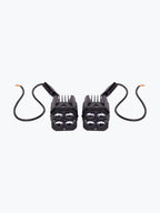Pair of black motorcycle LED auxiliary lights with cables on white background