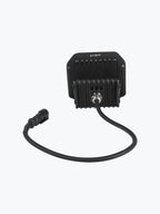Black LED motorcycle light with heat sink and power cable on white background