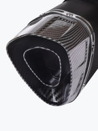 Close-up of a carbon fiber motorcycle exhaust tip with a modern angular design