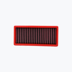 Rectangular red motorcycle air filter with pleated mesh on white background