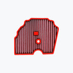 Red motorcycle air filter with pleated mesh element on white background