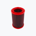 Red cylindrical motorcycle air filter with pleated mesh element on a light background