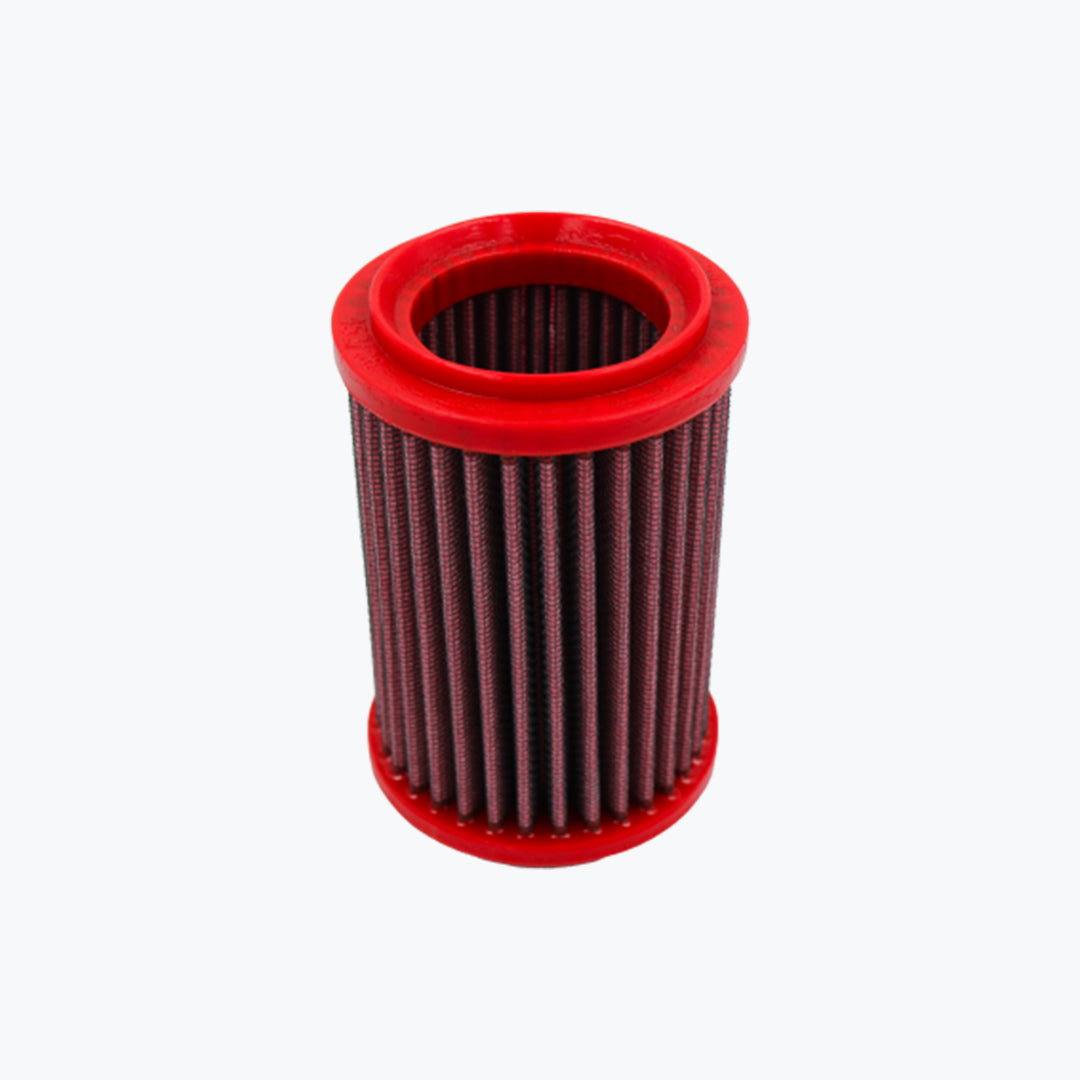 Red cylindrical motorcycle air filter with pleated mesh element on a light background