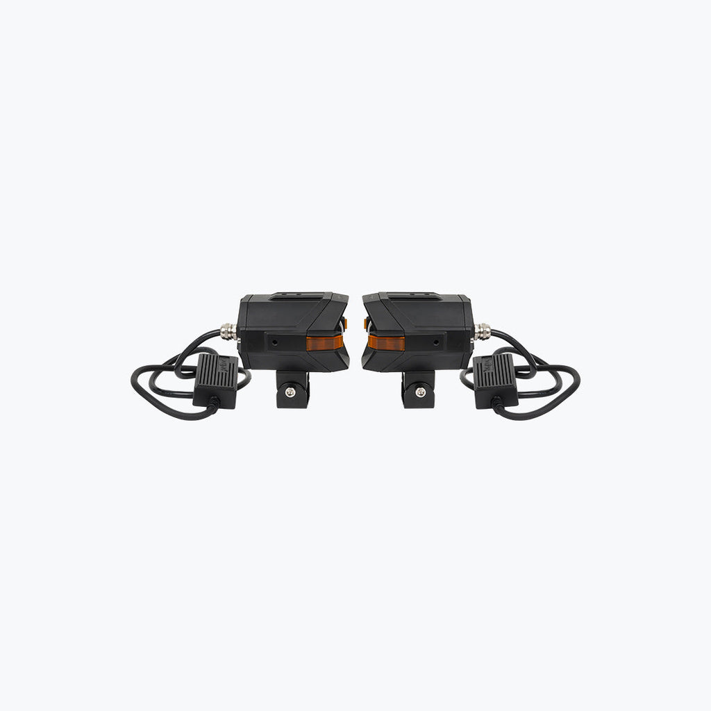 Pair of black motorcycle LED auxiliary lights with amber accents and mounting brackets
