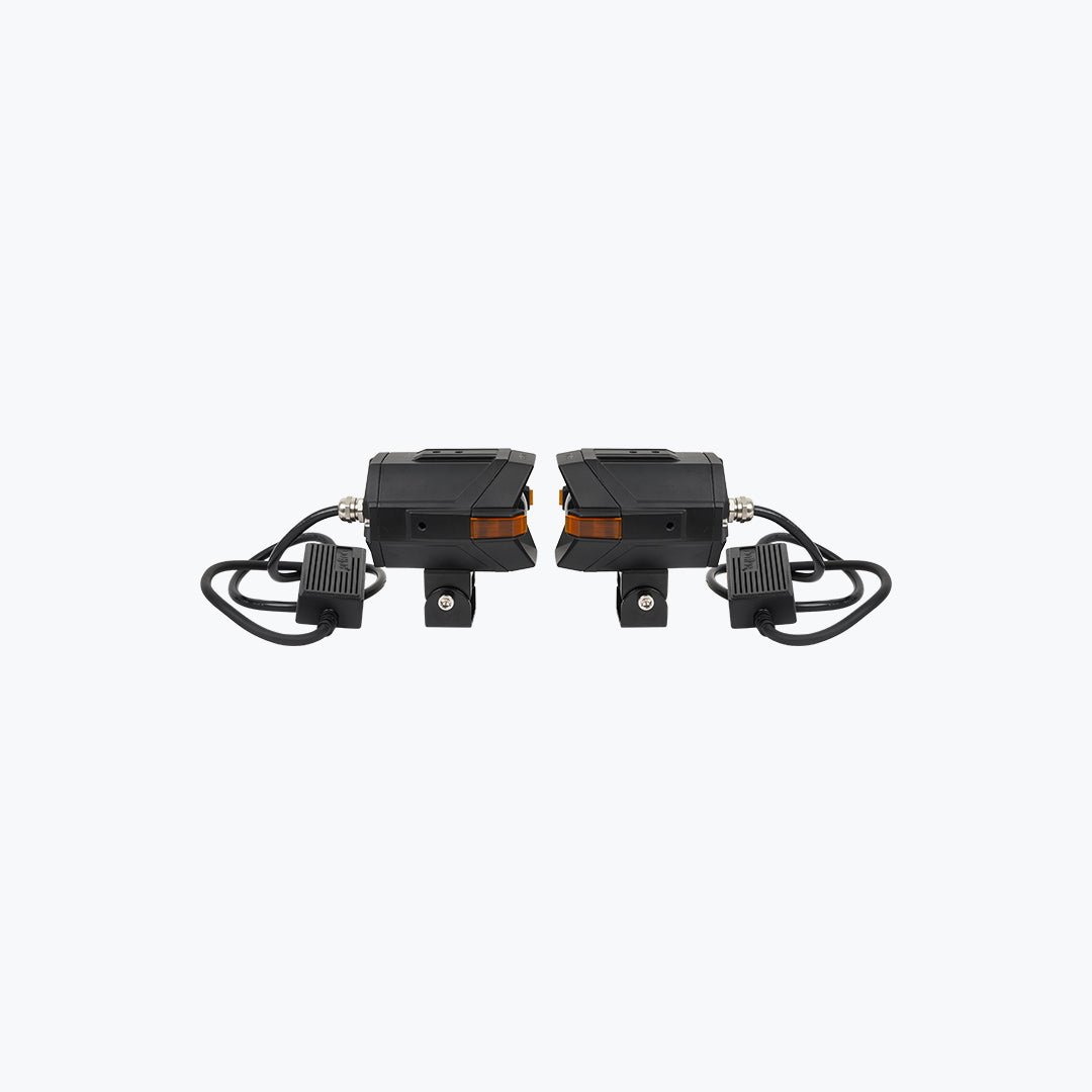 Pair of black motorcycle LED auxiliary lights with amber accents and mounting brackets