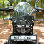 Motorcycle front view with clear windshield visor and headlight guard in outdoor setting