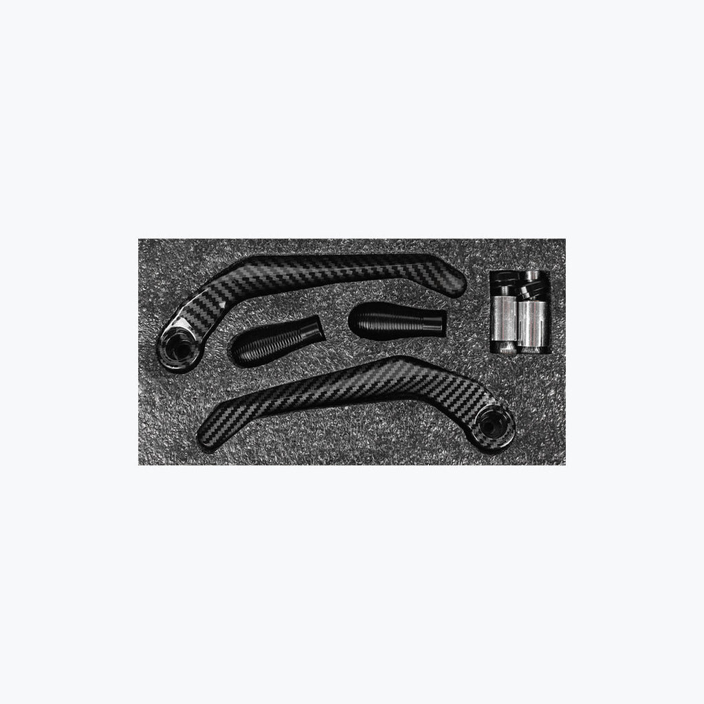 Carbon fiber motorcycle lever guards and handlebar grips set on black foam
