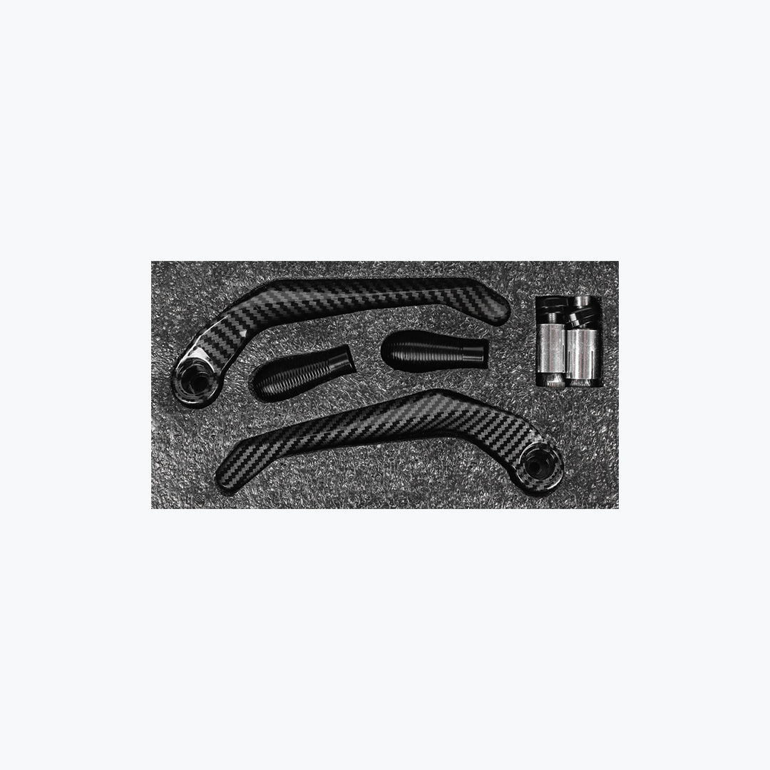 Carbon fiber motorcycle lever guards and handlebar grips set on black foam