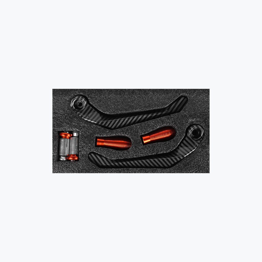 Carbon fiber motorcycle lever guard set with orange aluminum bar ends in foam packaging