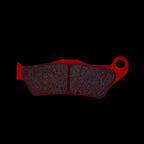 Front ceramic brake pad for KTM 125 RC DUKE, red backing, isolated on black background