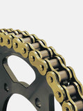 Close-up of a gold motorcycle drive chain on a black sprocket