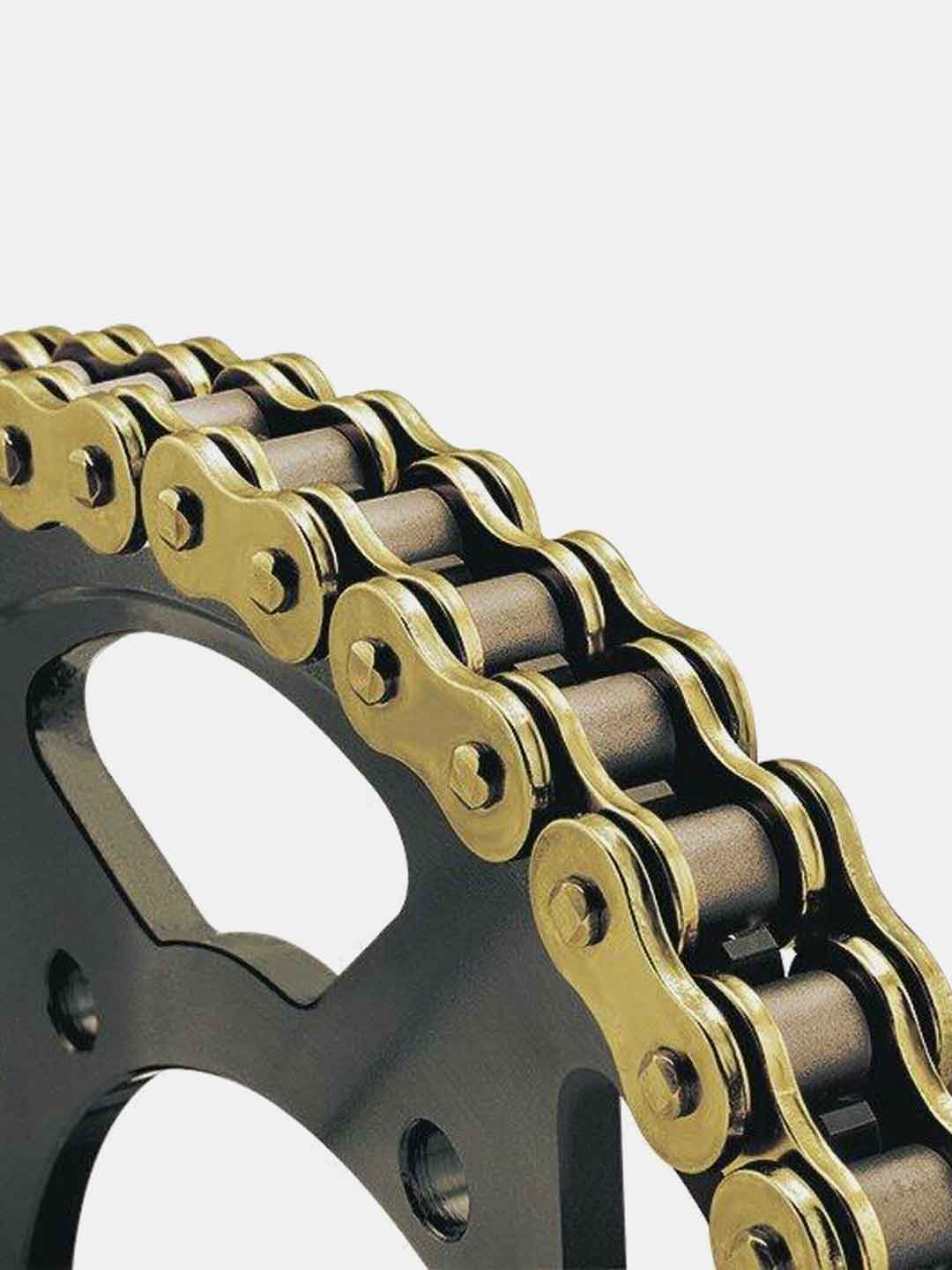 Close-up of a gold motorcycle drive chain on a black sprocket