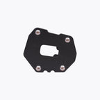 Black motorcycle side stand base plate with four silver screws on white background