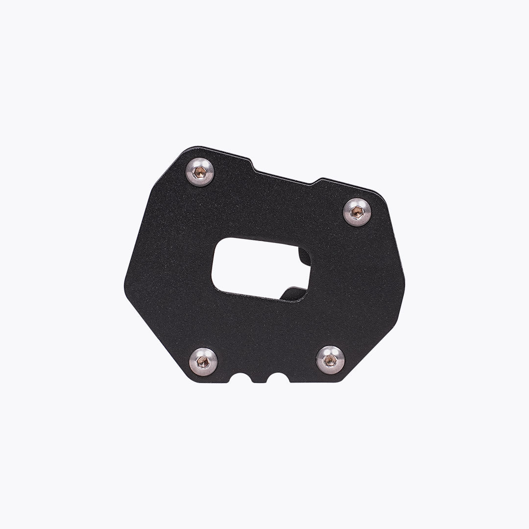 Black motorcycle side stand base plate with four silver screws on white background