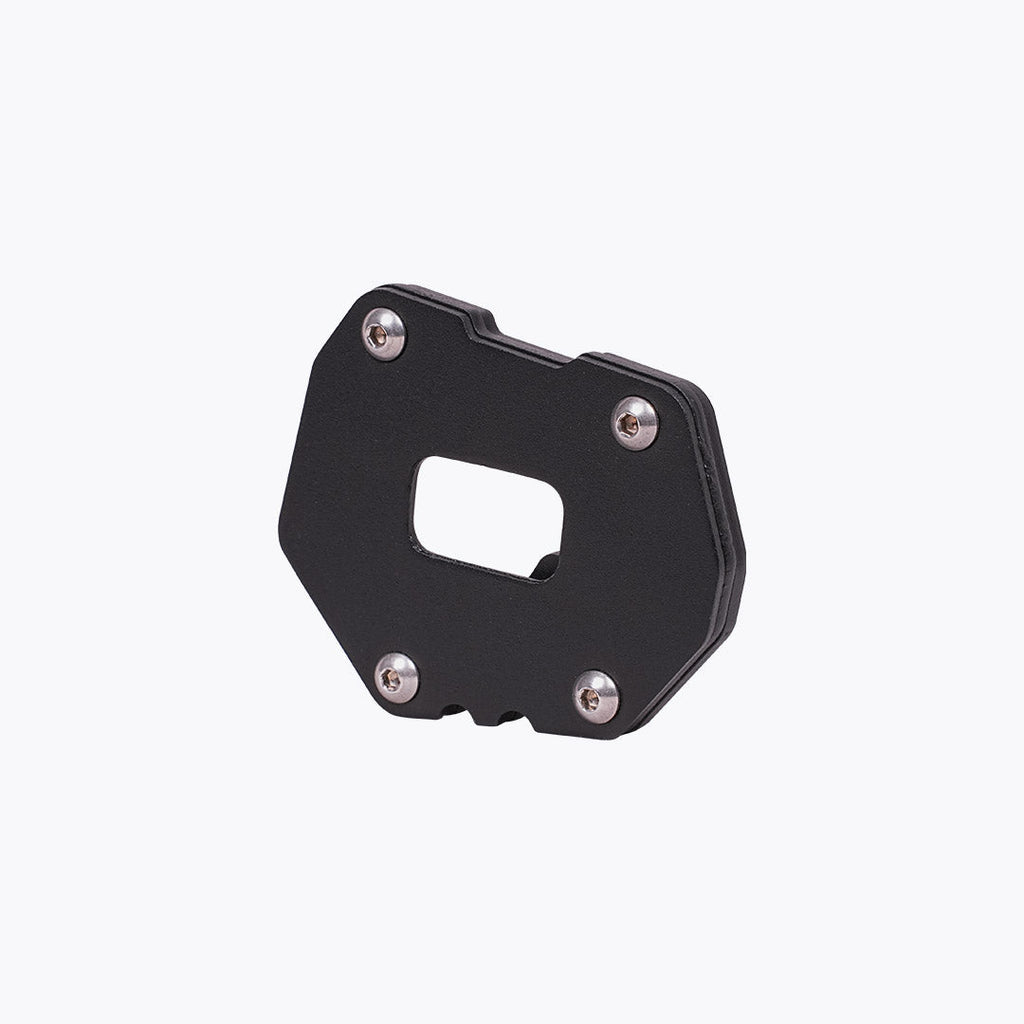 Black motorcycle side stand base plate with metal screws on white background
