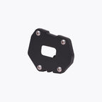 Black motorcycle side stand base plate with metal screws on white background