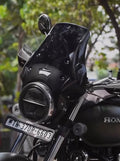 Close-up of Honda motorcycle with black windscreen, round LED headlight, and license plate