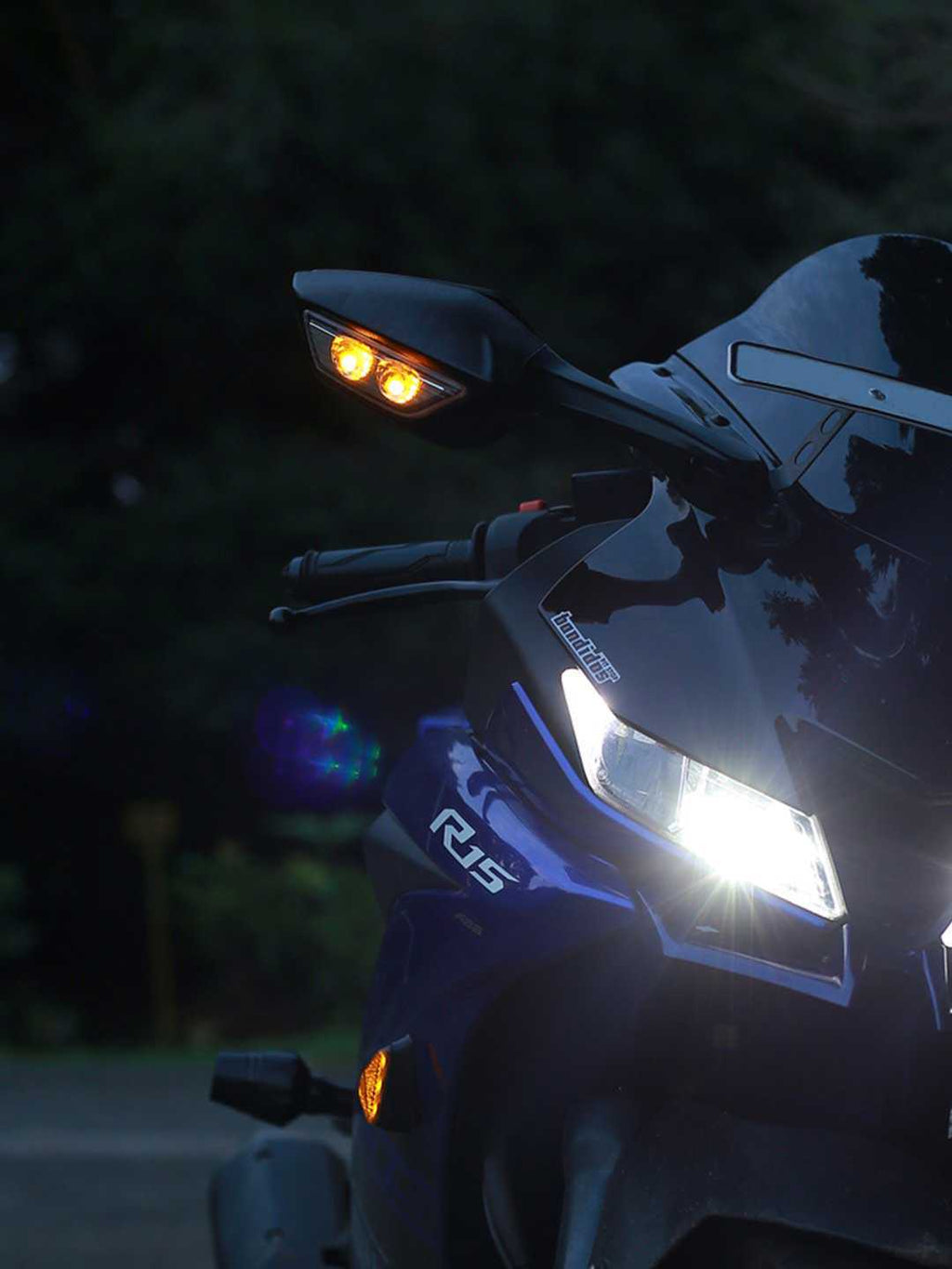 Sport motorcycle front view with illuminated LED headlight and turn signals at dusk