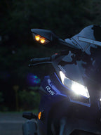 Sport motorcycle front view with illuminated LED headlight and turn signals at dusk