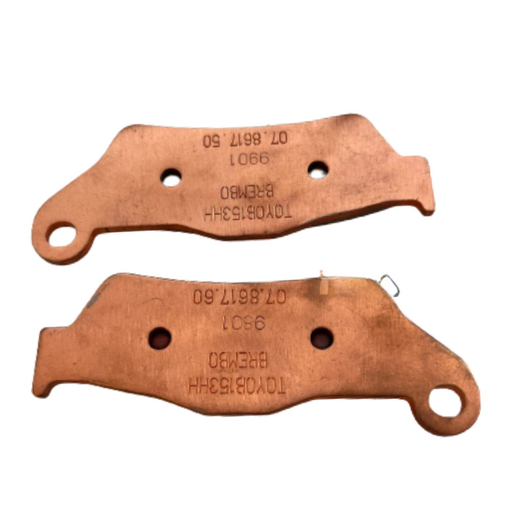 Copper motorcycle brake pads with engraved part numbers on a white background