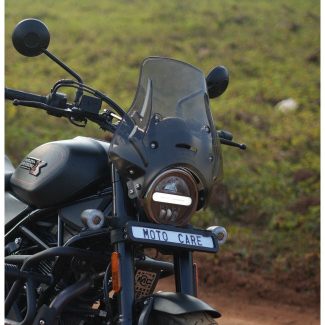 Motorcycle with polycarbonate visor and round headlight, Moto Care license plate visible
