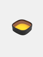 yellow fog light cover with black rubber edge on white background