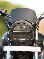 Black metal motorcycle headlight visor and grill with clear LED headlamp, front view
