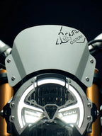 Close-up of Zephyr aluminium visor mounted on Triumph Speed 400 motorcycle, headlight illuminated