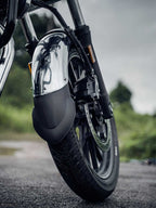 Close-up of motorcycle front wheel with chrome mudguard and mudguard flap on road
