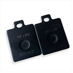 Black Nissin MN146EF motorcycle brake pad spacers on white background