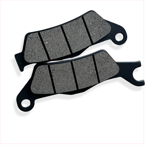 Motorcycle brake pads set on white background, close-up of friction material and grooves