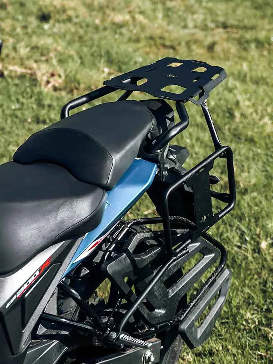 Motorcycle with rear luggage rack and saddle stay frame on grassy field