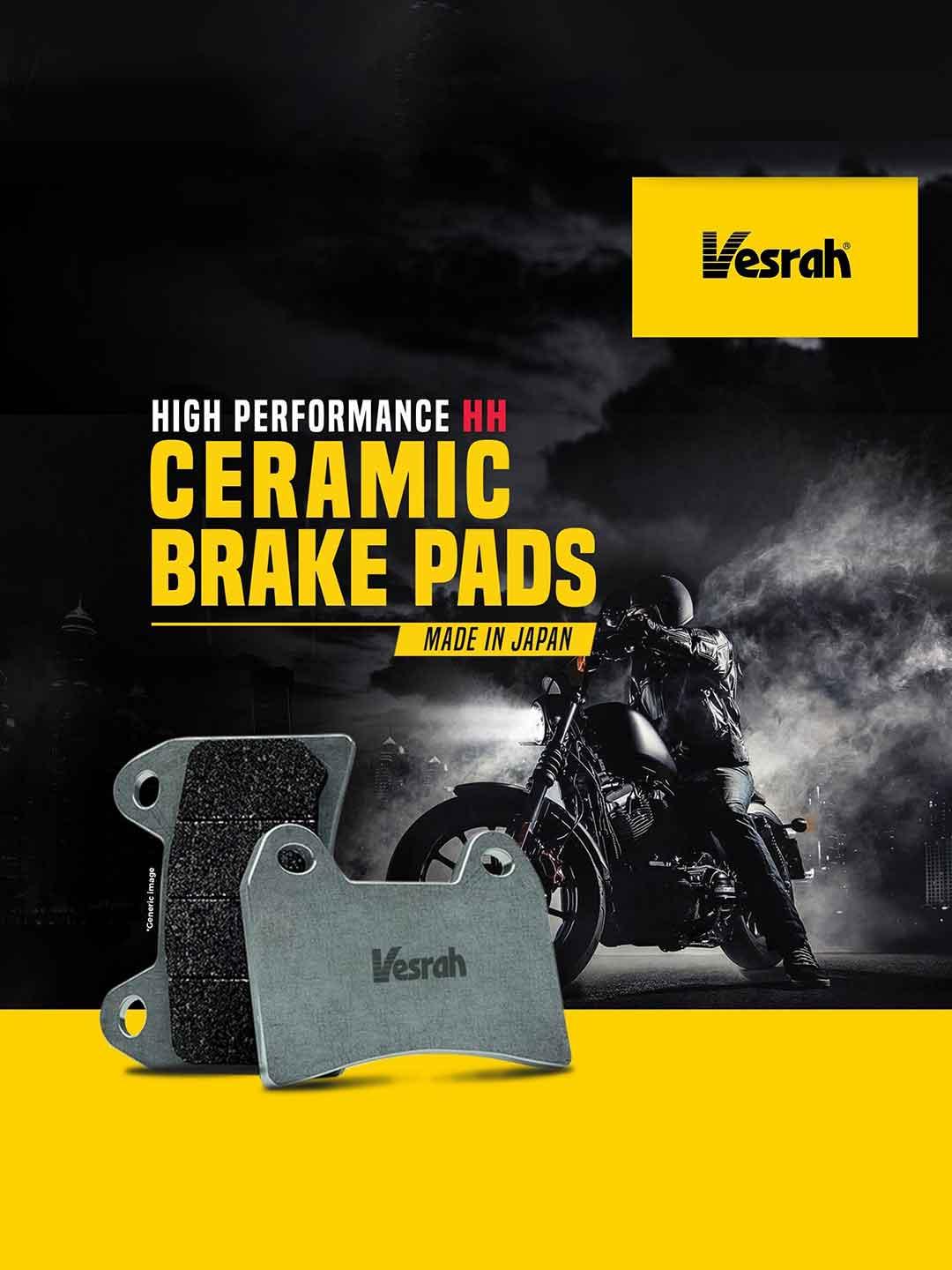 Vesrah ceramic brake pads in foreground, motorcycle and rider in smoky urban setting