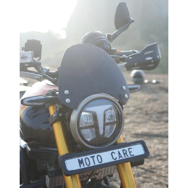 Motorcycle with round LED headlight, black visor, and 'MOTO CARE' license plate outdoors