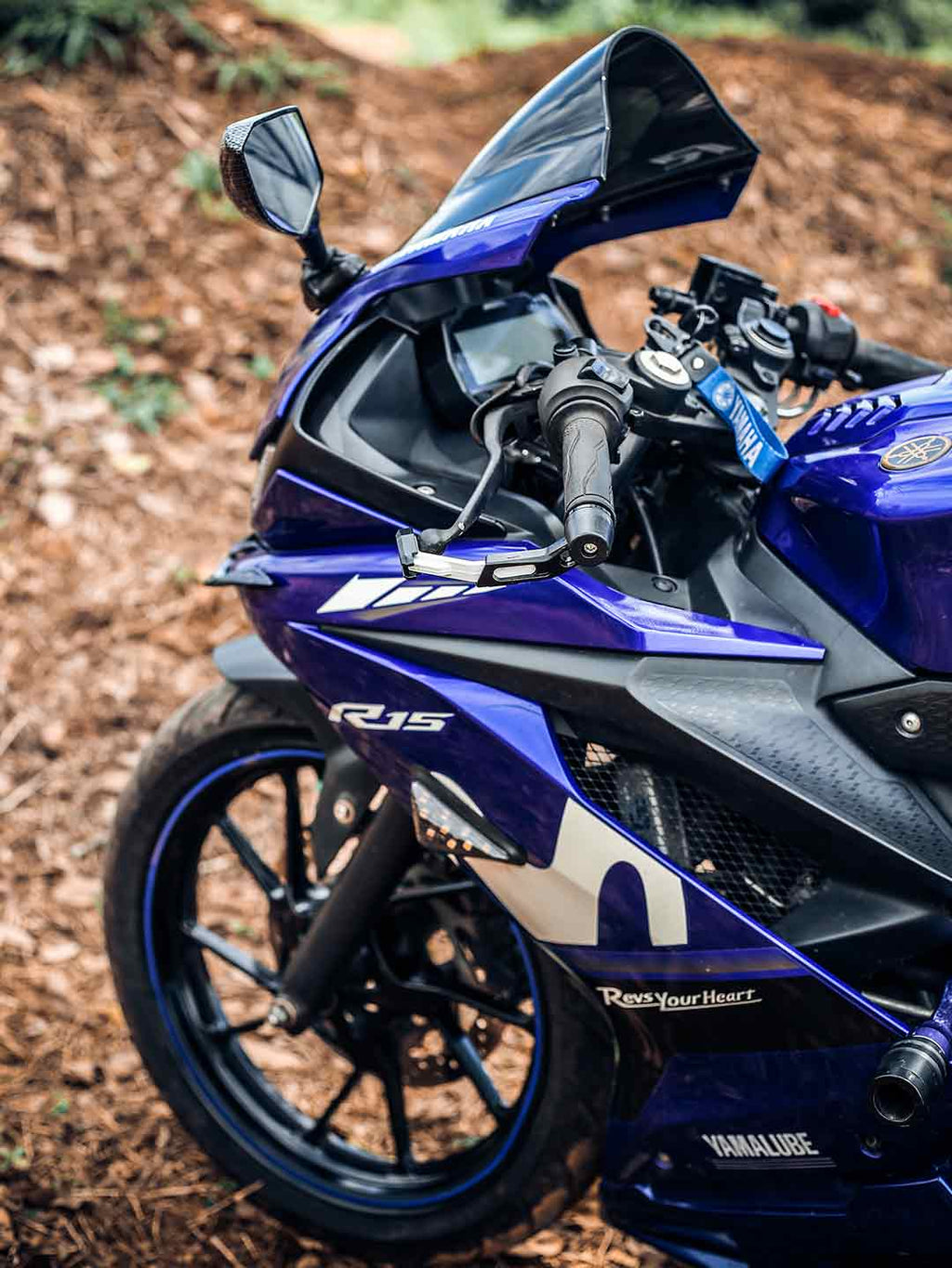 Close-up of blue Yamaha R15 sport motorcycle with visible handlebar and fairing outdoors